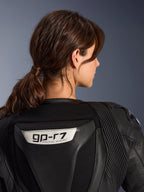 Alpinestars Stella GP-R7 2-delt læderdragt, sort, nærbillede af ryggen med GP-R7-logoet på den aerodynamiske pukkel, læder-harmonikapaneler på skuldrene, førsteklasses race-kvalitets konstruktion til kvinder.