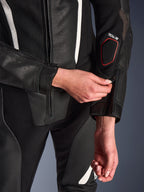 Nærbillede af Alpinestars Stella GP-R7 2-delt læderdragt i sort, med fokus på lynlåsjusteringen på underarmen, perforeret læderkonstruktion, hvide detaljer og Tech-Air-kompatibel branding på ærmet.