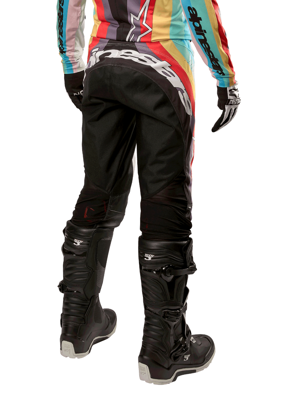 Alpinestars Stella 2024 Techstar bukser, motocross-bukser til damer, sort multifarvet, set bagfra med markant hvidt logo over bagen, båret med sorte Tech 3-støvler og matchende multifarvet jersey, professionelt off-road racerudstyr