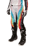 Alpinestars Stella 2024 Techstar bukser til damer, motocross-bukser, sort multicolor med diagonale røde, gule og blå striber, båret med sorte kørestøvler og hvide handsker, med beskyttende sorte knæpaneler og markant branding til off-road racing.