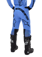 Alpinestars 2024 Supertech Dade bukser, motocross-bukser, lyseblå, set bagfra med stor sort branding på bagdelen og benene, båret med sorte Alpinestars Tech 10 støvler, atletisk racerpasform til professionel terrænkørsel.
