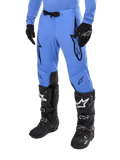 Alpinestars 2024 Supertech Dade bukser, motocross-bukser, lyseblå med sorte grafiske logoer, med ventilerede perforeringer og magnetisk taljespænde, kombineret med sorte tekniske kørestøvler og handsker, professionelt off-road racerudstyr