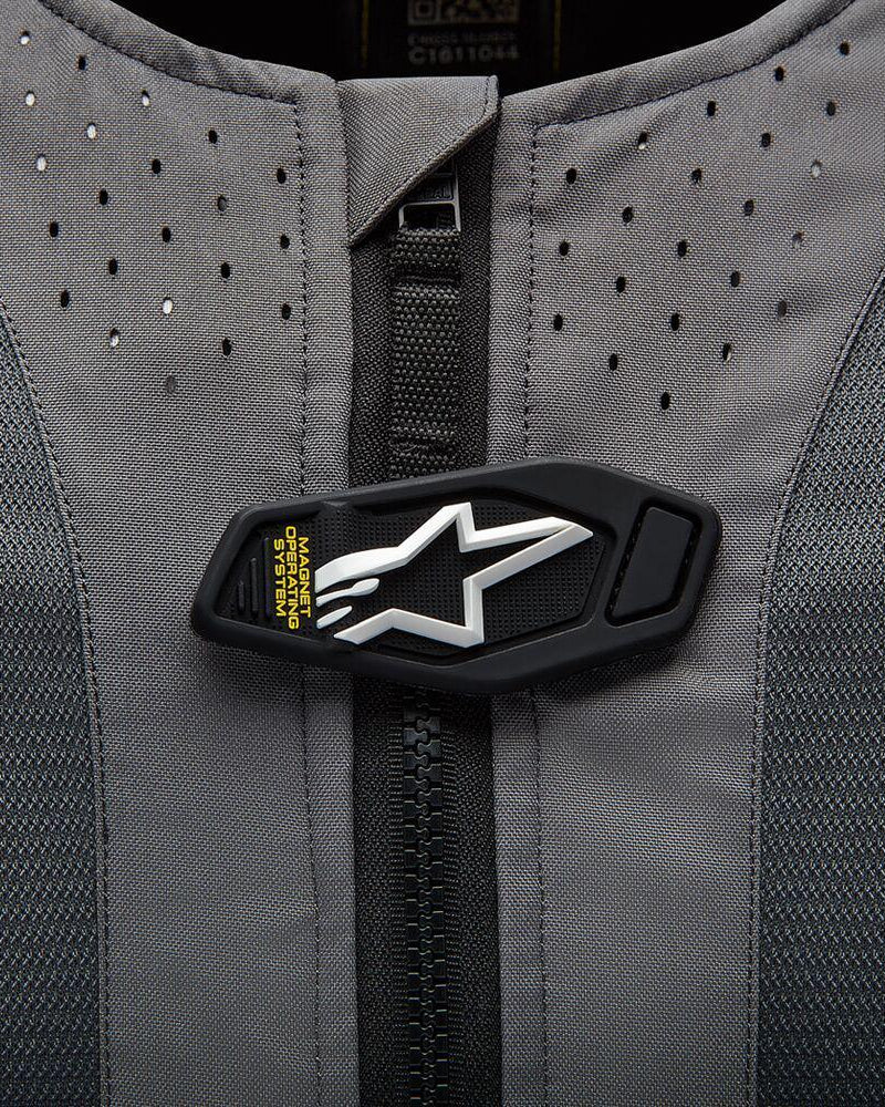 Alpinestars Tech-Air® 5 System, magnetisk flap med hvidt stjernelogo på gråt perforeret stof.