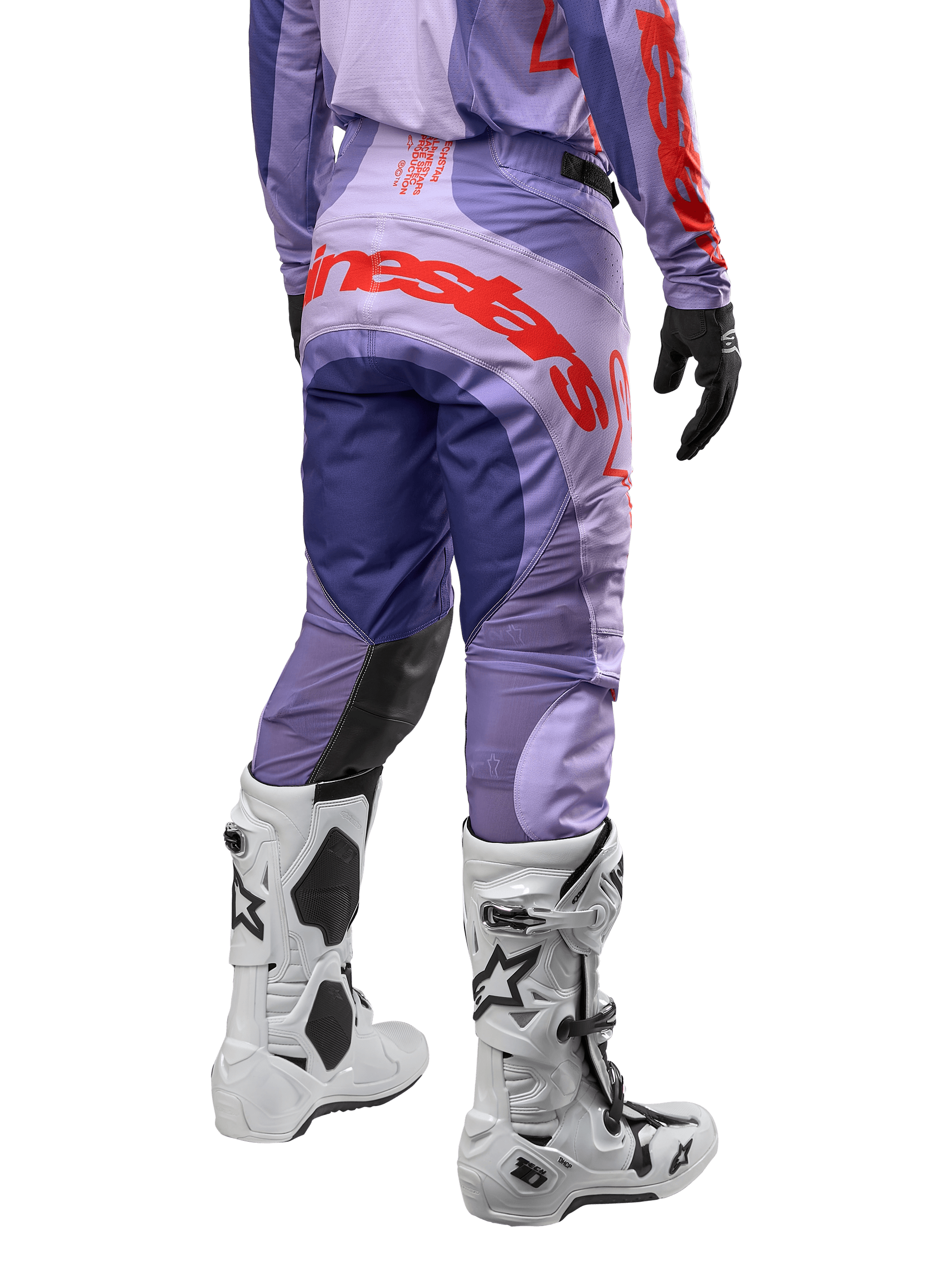 Alpinestars 2024 Techstar Ocuri bukser, motocross off-road bukser, lilla med kraftige orange detaljer, set bagfra, hvide Tech 10 støvler, professionelt racingudstyr til terrænkørsel
