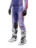 Alpinestars 2024 Techstar Ocuri bukser, motocross- og terrænbukser til mænd, lilla og mørkeblå med røde og orange detaljer, hvide motocross-støvler, sorte handsker, professionelt beskyttelsesudstyr til racing