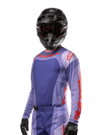 Alpinestars 2024 Techstar Ocuri Jersey, motocross racingtrøje, lilla og stærk orange, langærmet med laser-skårne perforeringer for ventilation, atletisk race-pasform, vist med sort motocrosshjelm og sorte handsker