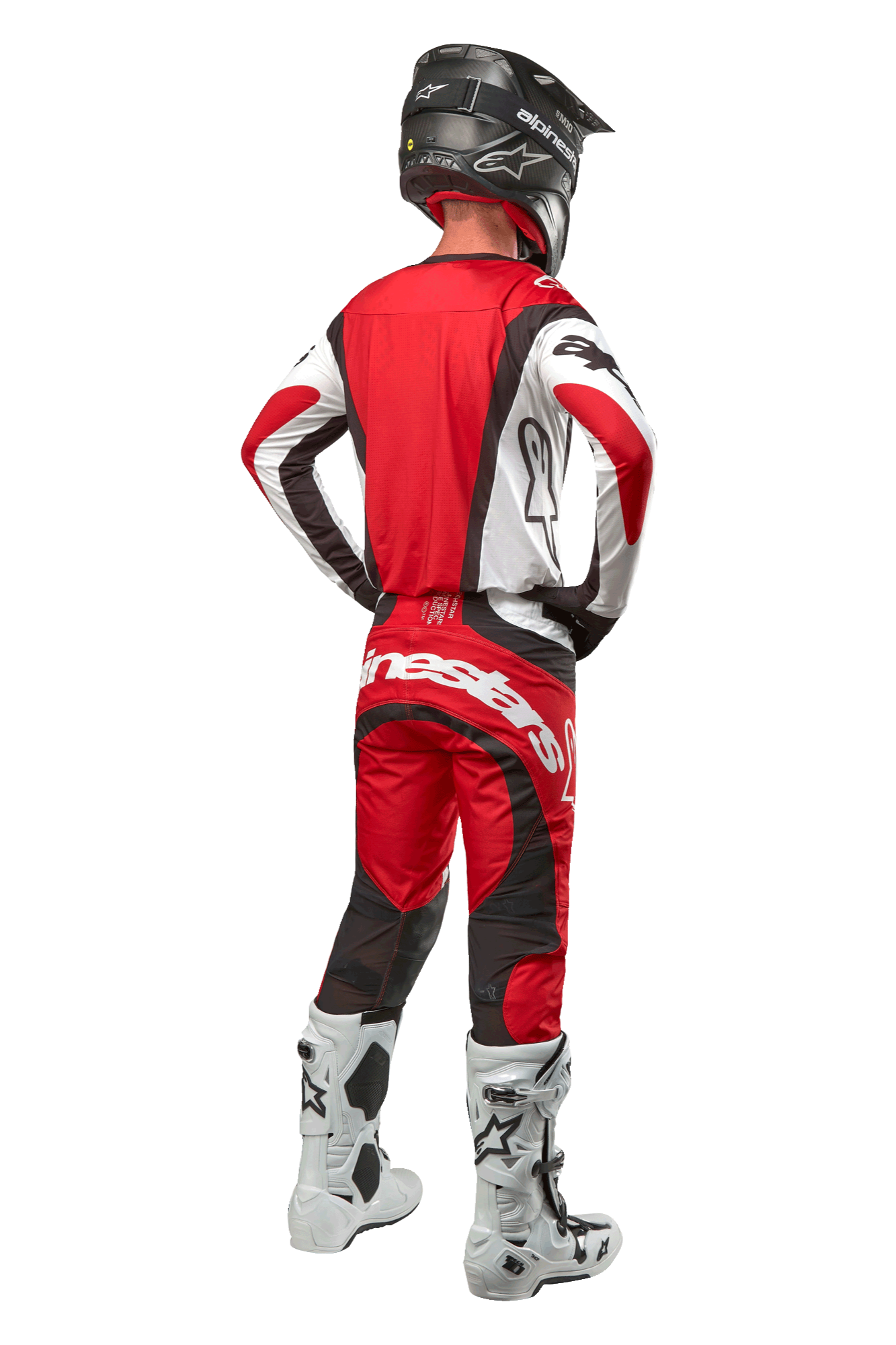 Alpinestars 2024 Techstar Ocuri bukser, motocrossbukser, Mars rød, hvid og sort, set bagfra af en motocrosskører iført fuldt racerudstyr, herunder matchende trøje, sort hjelm og hvide og sorte støvler, hvilket fremhæver Alpinestars-branding og den slidstærke tekstilkonstruktion.