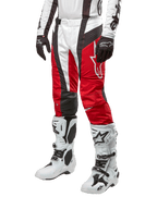 Alpinestars 2024 Techstar Ocuri bukser, motocross-racerbukser, Mars rød, hvid og sort, båret med matchende hvid og sort trøje, sorte handsker og hvide racerstøvler med spænder, teknisk beskyttelsesudstyr vist på en hvid baggrund