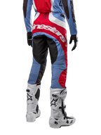 Alpinestars 2024 Techstar Ocuri bukser, motocross-bukser, lyseblå, Mars-rød og hvid, set bagfra hvilket fremhæver det store røde Alpinestars-logo over sædet, båret med hvide racingstøvler og matchende jersey.
