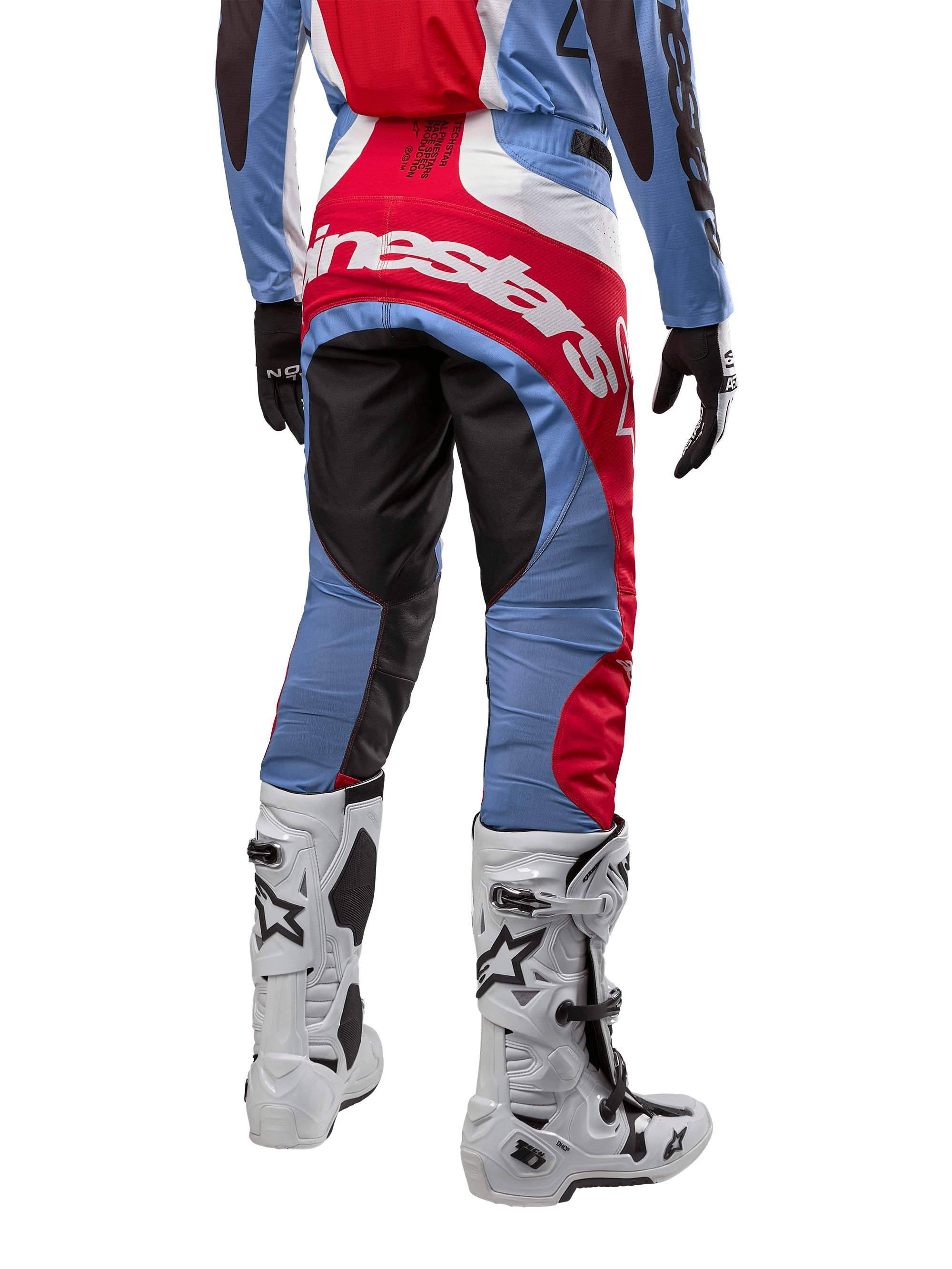 Alpinestars 2024 Techstar Ocuri bukser, motocross-bukser, lyseblå, Mars-rød og hvid, set bagfra hvilket fremhæver det store røde Alpinestars-logo over sædet, båret med hvide racingstøvler og matchende jersey.
