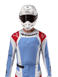 Alpinestars 2024 Techstar Ocuri trøje, motocross racingtrøje, lyseblå, Mars-rød og hvid, set forfra med laserskåret ventilation og atletisk pasform, båret med hvid hjelm og goggles for et professionelt off-road racing-look