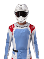 Alpinestars 2024 Techstar Ocuri trøje, motocross racingtrøje, lyseblå, Mars-rød og hvid, set forfra med laserskåret ventilation og atletisk pasform, båret med hvid hjelm og goggles for et professionelt off-road racing-look