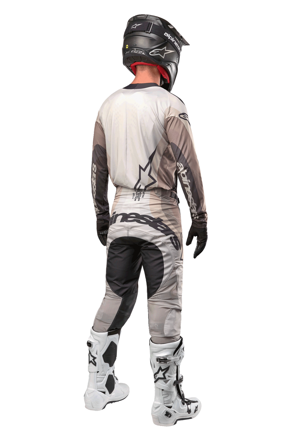 Alpinestars 2024 Techstar Pneuma bukser, motocross-bukser, Dark Sand og Iron Dust Gray, set bagfra båret af en kører med en matchende jersey, hvide og sorte støvler og en sort hjelm, med markant Alpinestars-branding på sædet og forstærkede mørke paneler