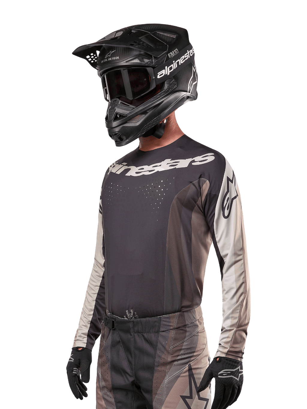 Alpinestars 2024 Techstar Pneuma trøje, motocross-racingtrøje, Dark Sand og Iron Dust Gray, langærmet performance-top med laserskårne perforeringer og hvid branding, båret med matchende bukser og sort hjelm, atletisk pasform til off-road kørsel.