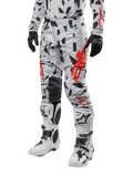 Alpinestars 2024 Techstar Rantera bukser, motocross-bukser, Haze Gray Camo med sort og rødt abstrakt mønster, bæres med matchende trøje, sorte handsker og hvide motocross-støvler, designet til højtydende off-road kørsel