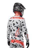 Motocrossrytter set bagfra iført Alpinestars 2024 Techstar Rantera Jersey i Haze Gray Camo, lysegrå base med sorte grafiske pletter og markante røde Alpinestars-logoer på ryggen og skuldrene, kombineret med matchende bukser og en sort hjelm.