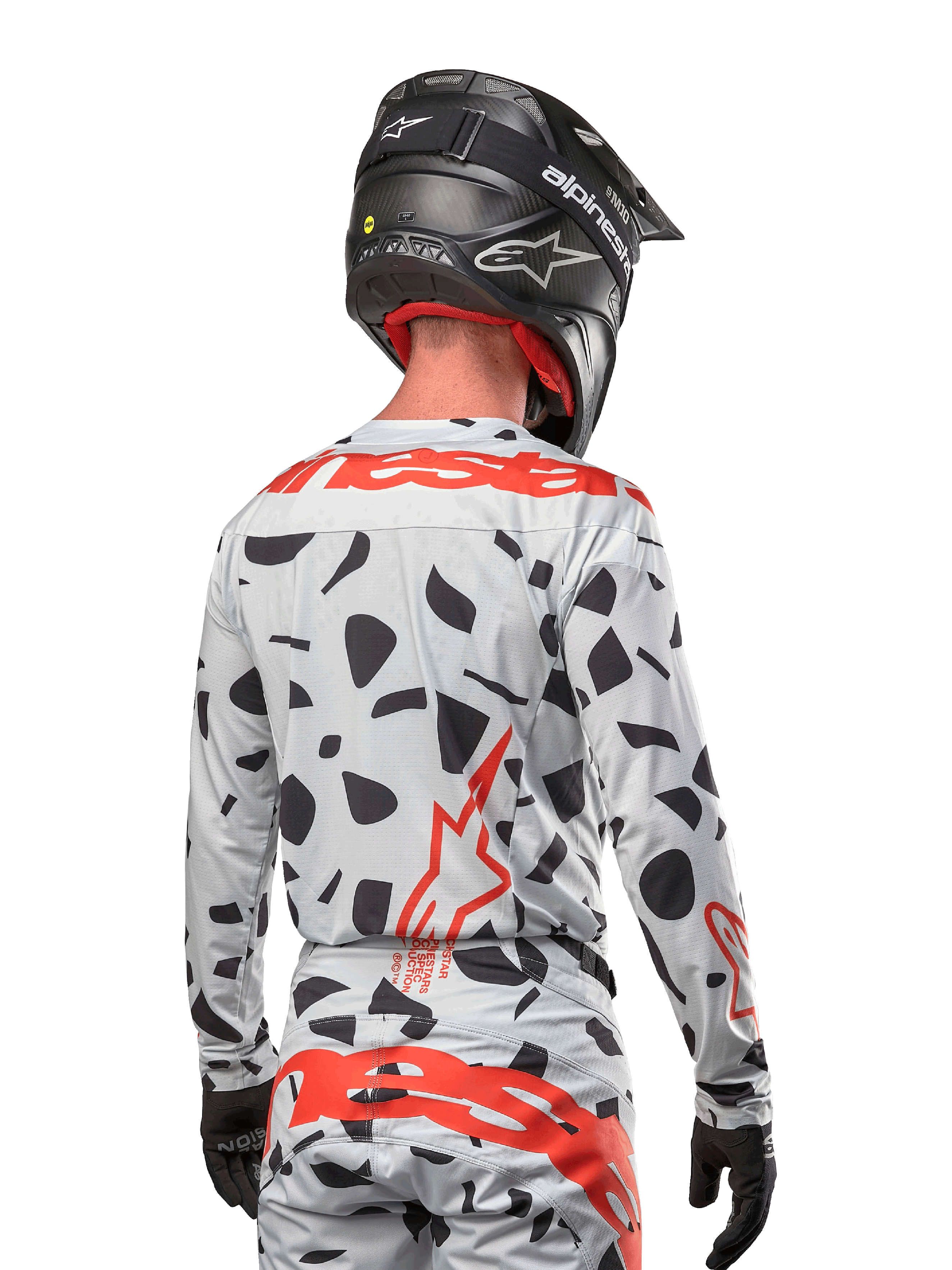 Motocrossrytter set bagfra iført Alpinestars 2024 Techstar Rantera Jersey i Haze Gray Camo, lysegrå base med sorte grafiske pletter og markante røde Alpinestars-logoer på ryggen og skuldrene, kombineret med matchende bukser og en sort hjelm.