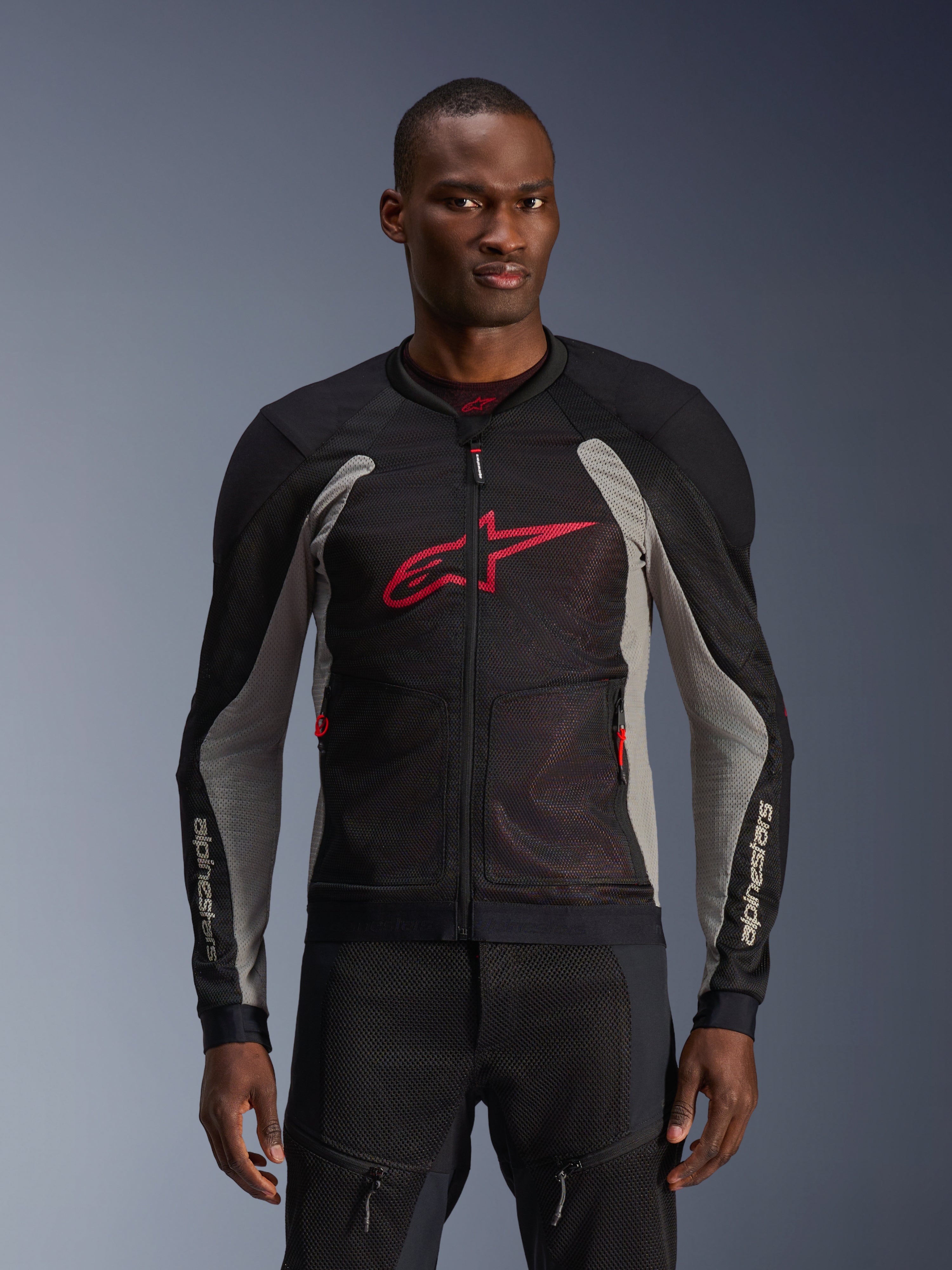 Alpinestars Troop-Air jakke, motorcykel mesh-jakke, sort og askegrå med klare røde detaljer, båret af en model, åndbare 2D tech mesh-paneler til ventilation, stort rødt Astars-logo på brystet, teknisk sporty design til urban kørsel