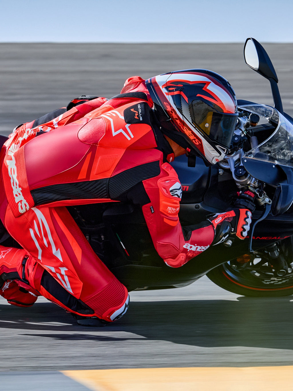 Alpinestars GP Plus V4 Sprint læderdragt 1-stk, racing, rød og hvid, Tech-Air® klar, motorcyklist i sving på racerbane.