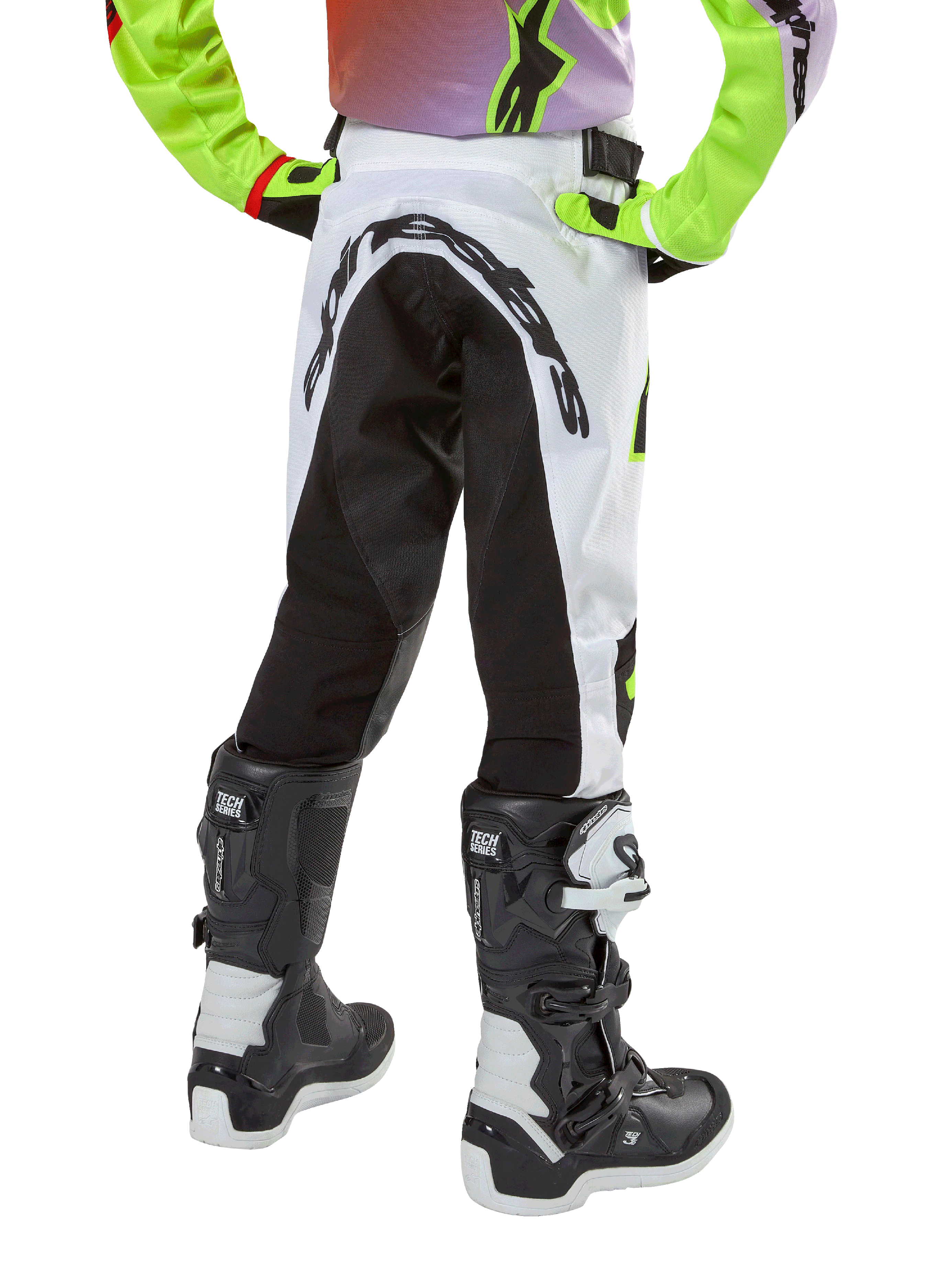 Alpinestars Youth 2024 Racer Lucent Pants, Motocross Pants, White and Black with Neon accents, back view showing large rear stretch panel and Alpinestars logo, worn with black and white Alpinestars Tech Series boots.