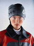 Alpinestars RSRV Onyx hue, unisex strikket hue, mørkegrå med hvide detaljer, ovale udskæringer på siden, vist på person iført rød og sort jakke med høj krave