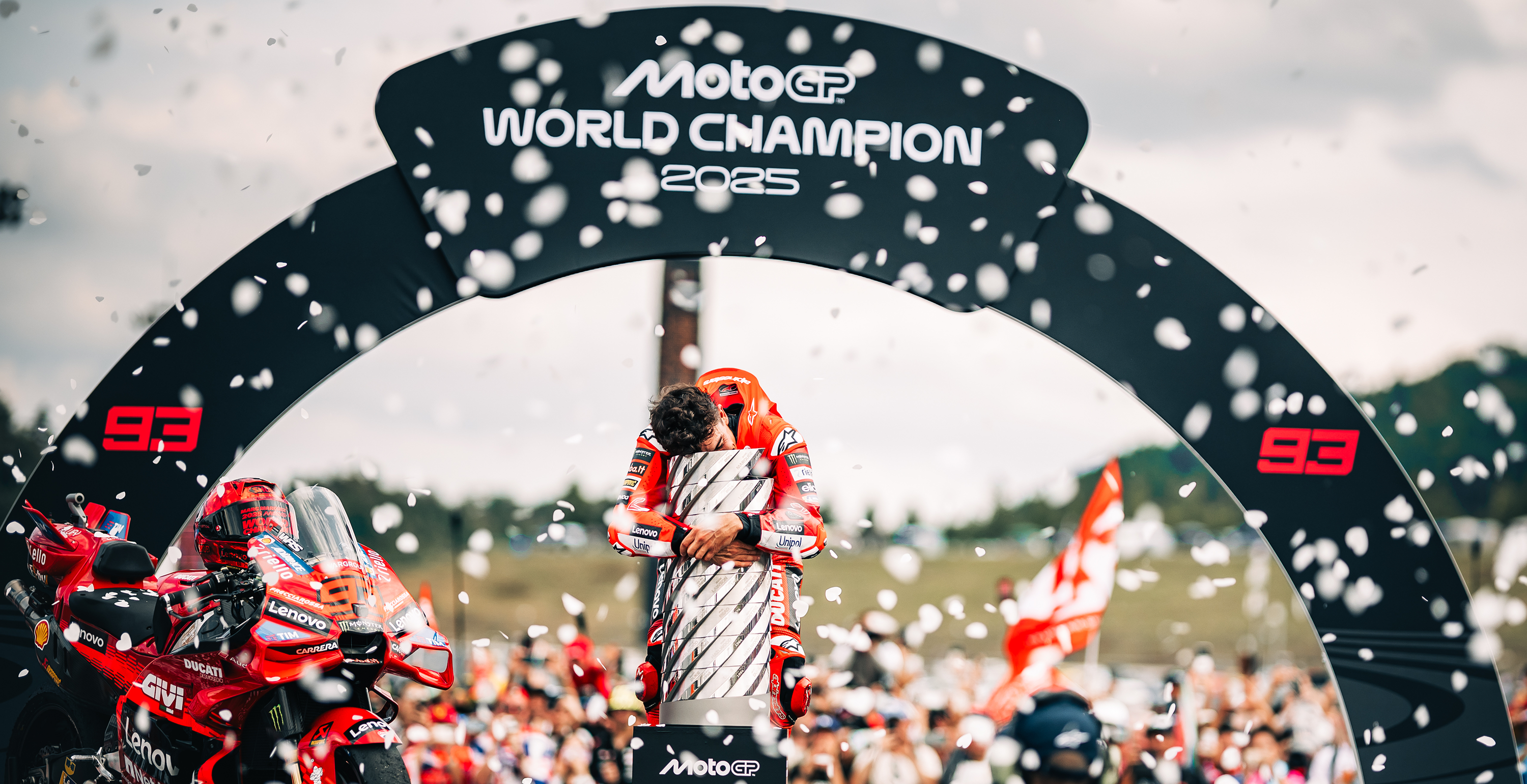 Marc Marquez celebrating the 2025 MotoGP win next to his Ducati