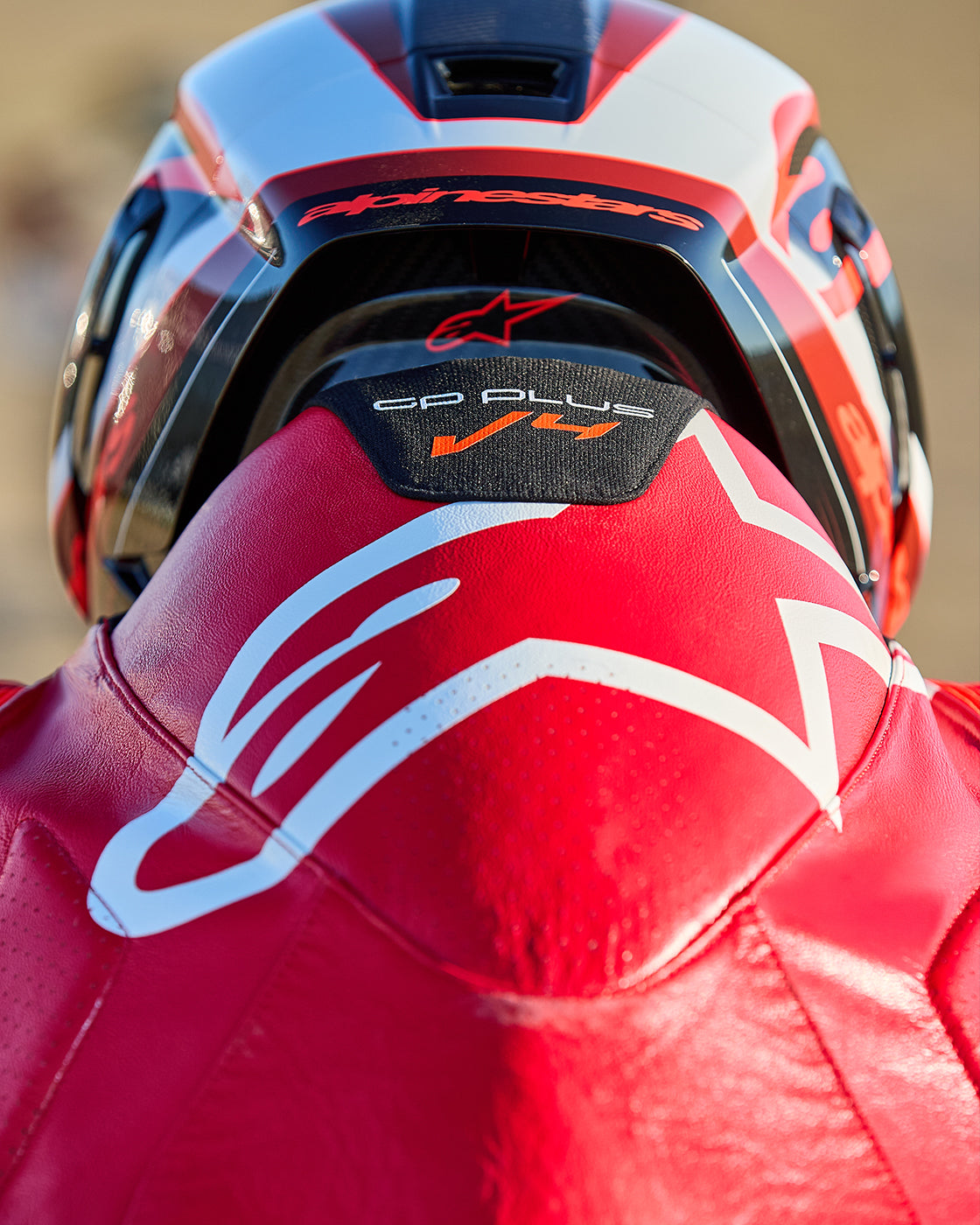 Alpinestars Gp Plus V4 Sprint 1 Piece Leather Suit in red and white with an aerodynamic hump for motorcycle racing.
