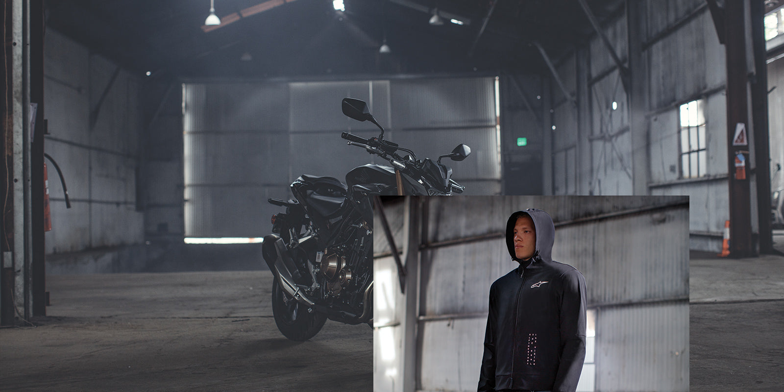 Alpinestars Radium Tech Hoodie, Men's Black Motorcycle Jacket, windproof 3L shell, styled with a bike in an urban garage.